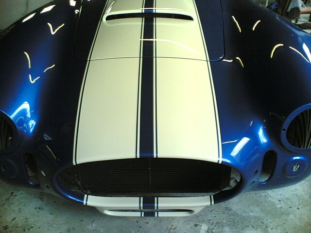 White racing stripes over a gloss blue Cobra bonnet