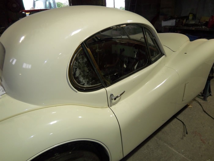 Side view of the cream Jaguar XK140 coupe