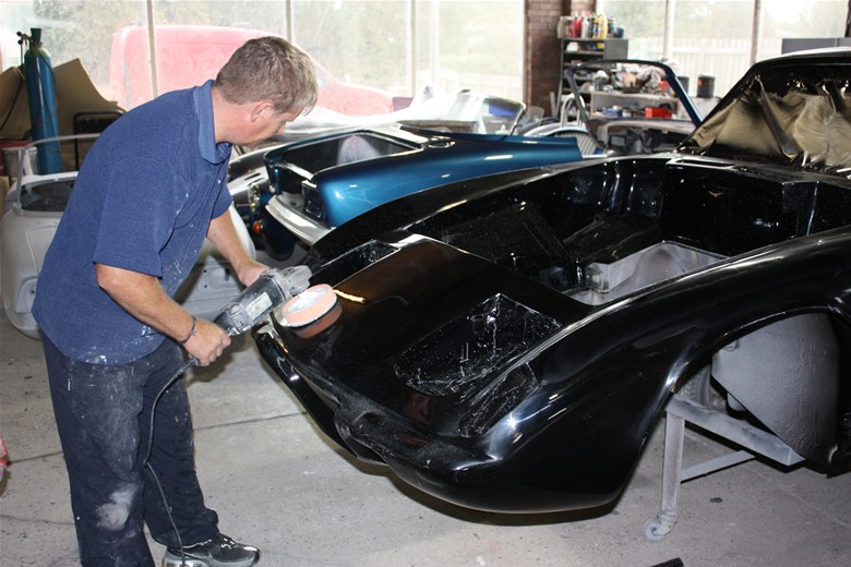 Polishing the black paintwork of a Lotus body